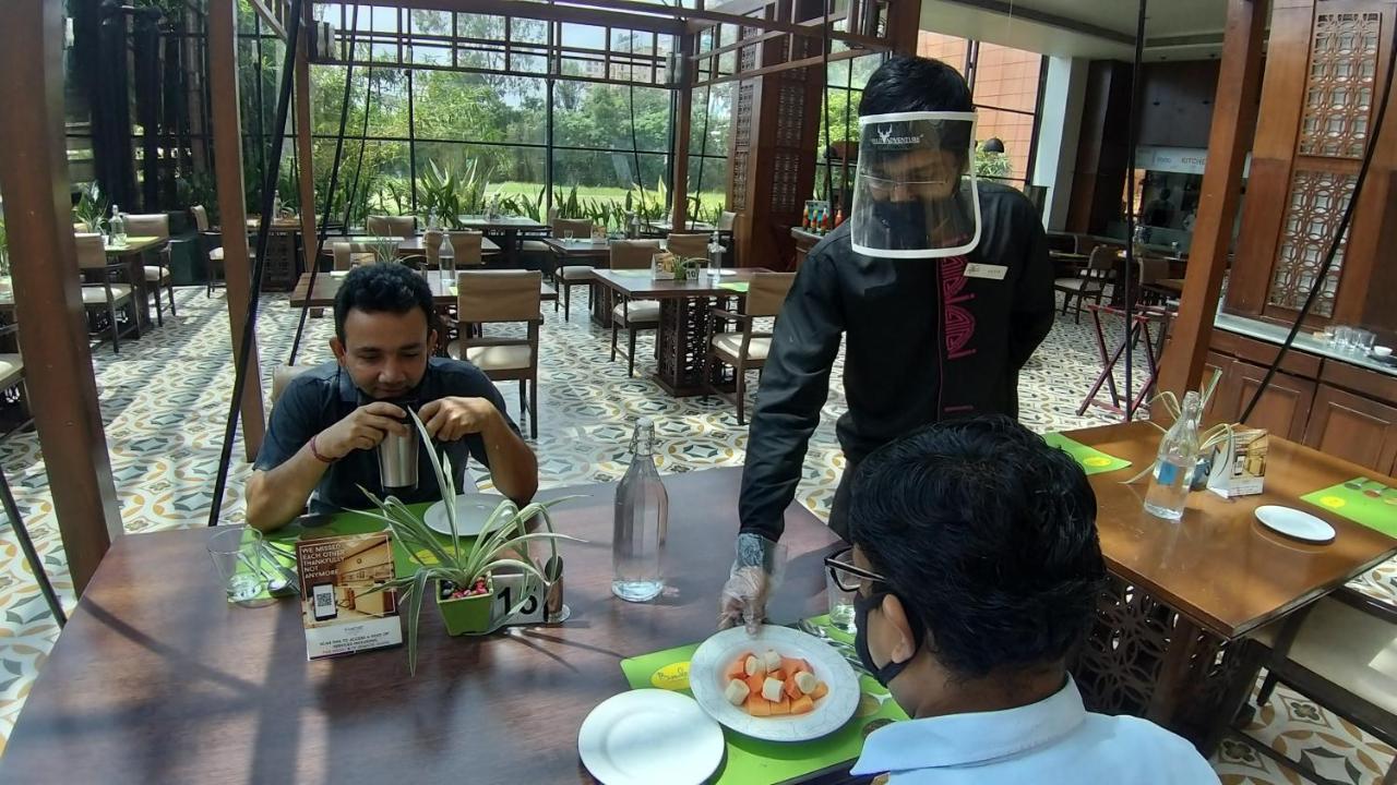 The Orchid Hotel Hinjewadi Pune Eksteriør bilde A restaurant in India with a waiter wearing a face shield